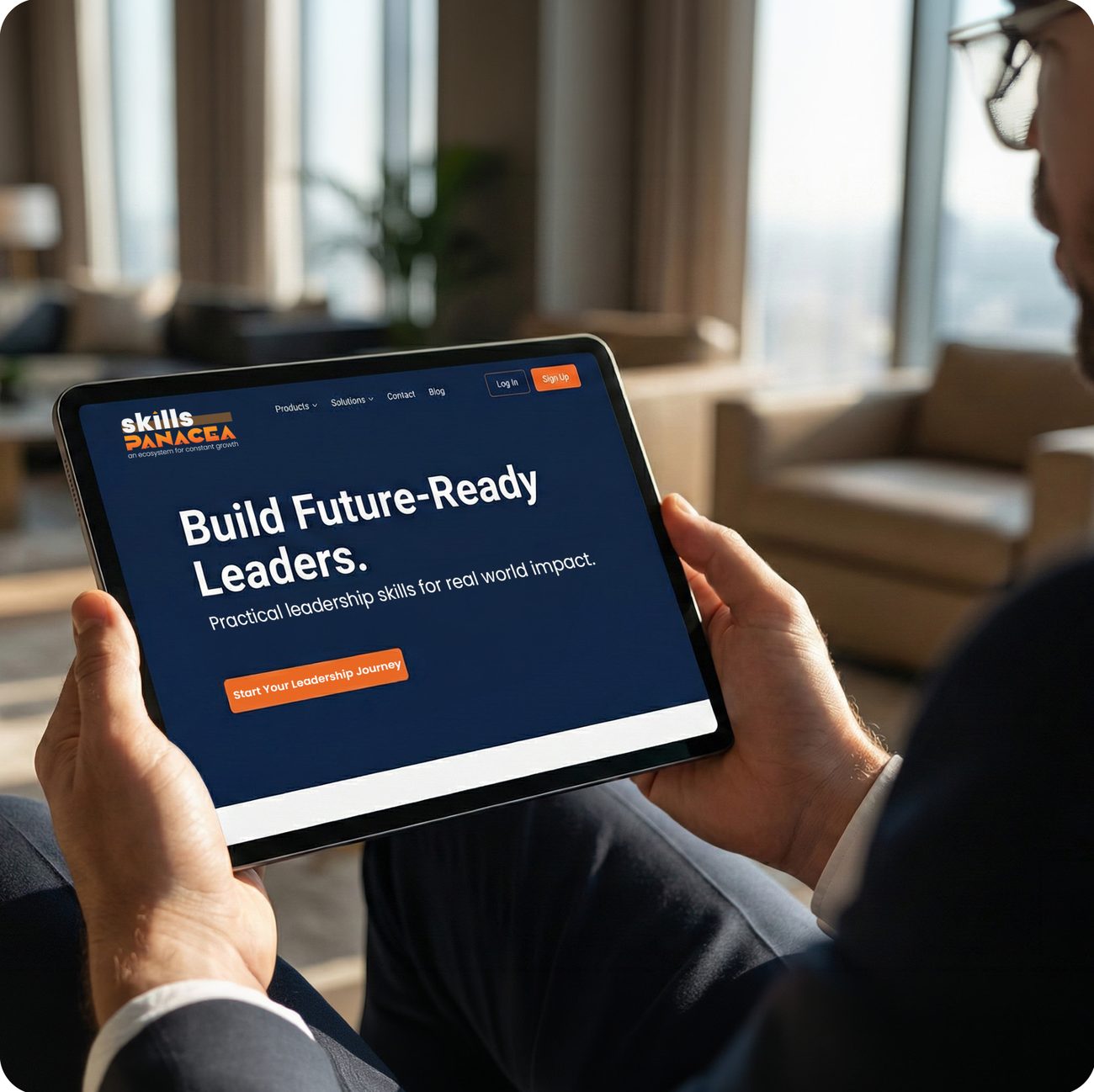 Executive holding a tablet showing the Skills Panacea website: Build Future-Ready Leaders